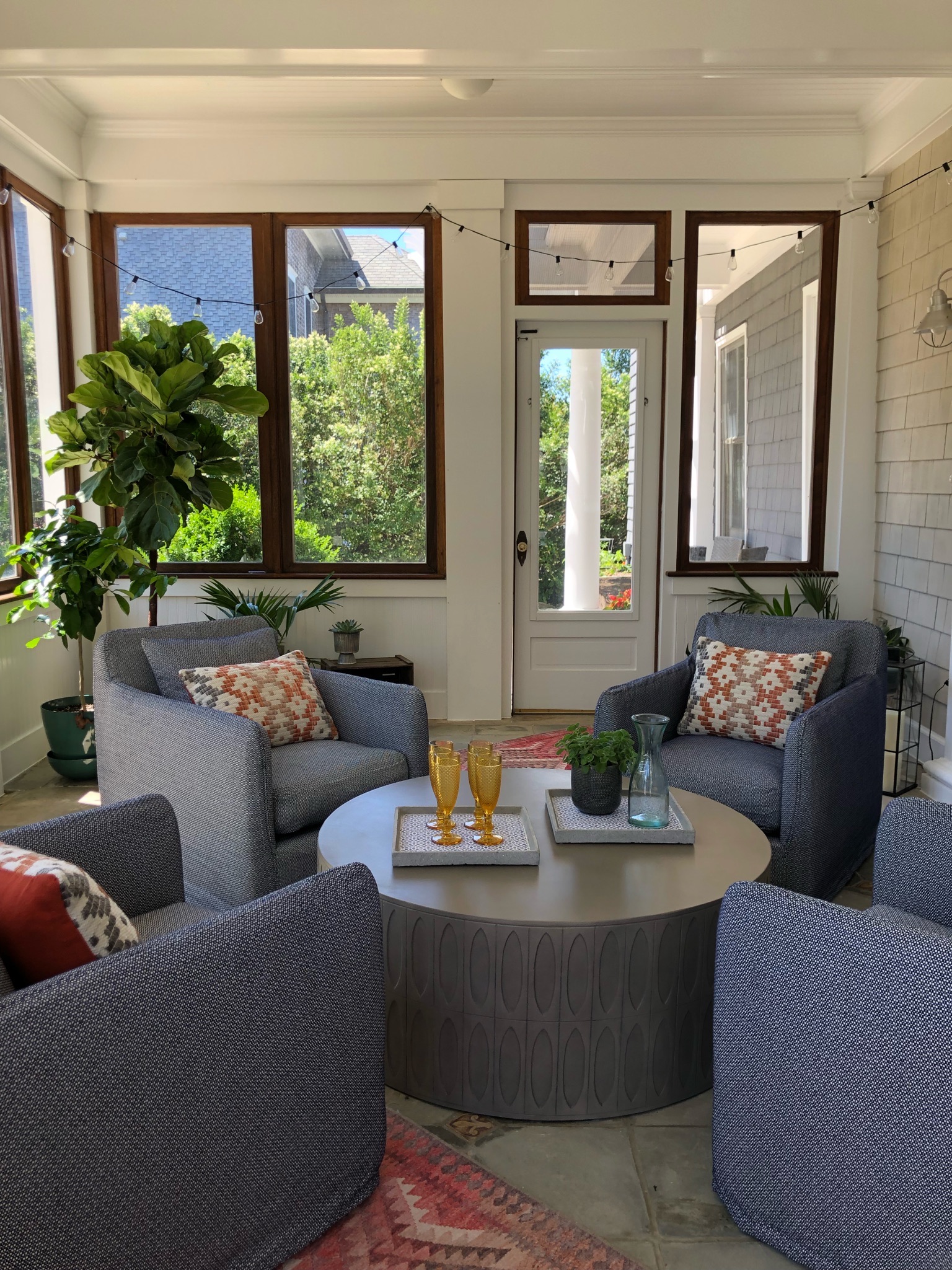 sunroom with 4 couch and table with glasses and pitcher