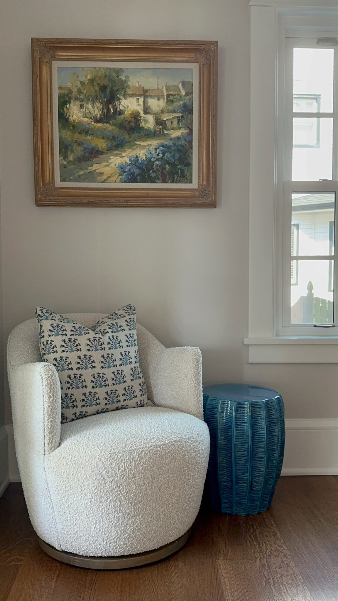 A chair strategically placed in front of a window, perfectly complementing the interior design with the added touch of a captivating painting.