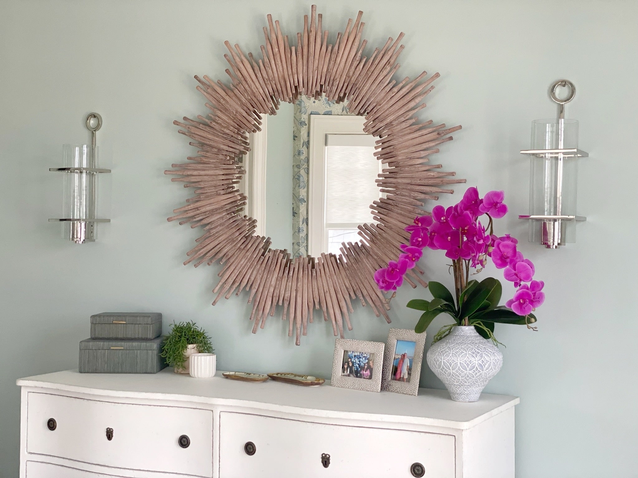 A white dresser with a sunburst mirror, perfect for interior design.