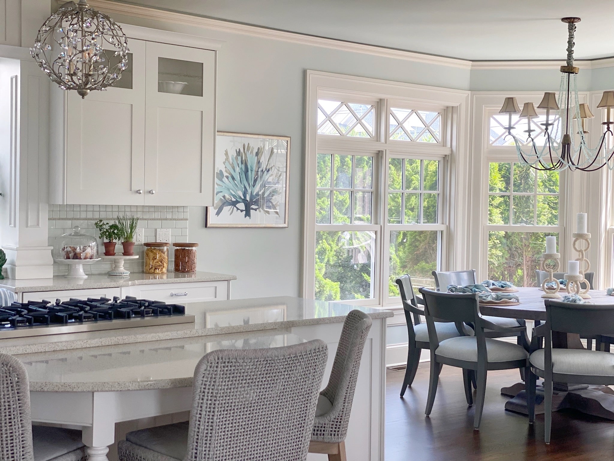 A kitchen with a chic design featuring a table and chairs, accented by an elegant chandelier.