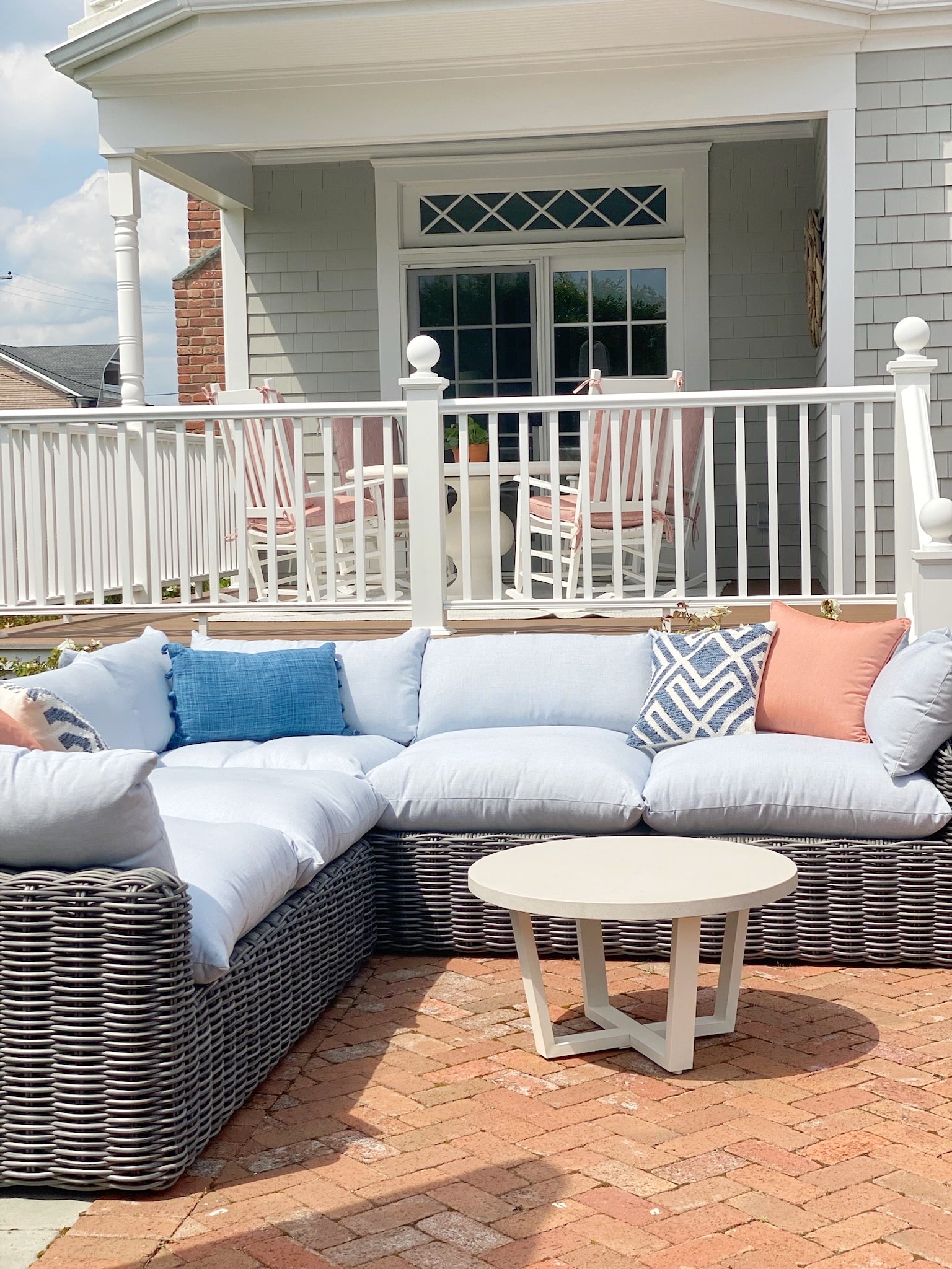 A wicker patio furniture set on a brick patio, adding a touch of design to the outdoor space.