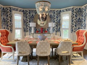 An interior design featuring a dining room with blue wallpaper and orange chairs.